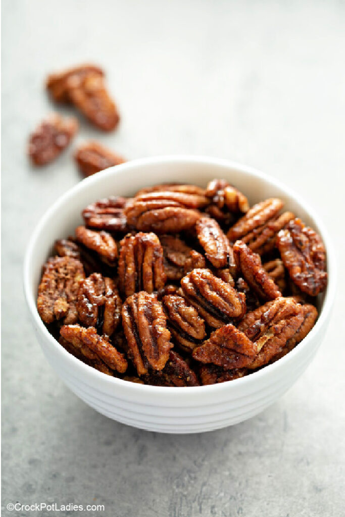 a white bowl of pecans that have been sugared