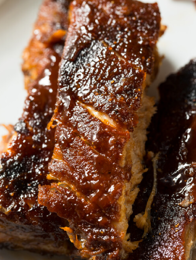a plate of country style ribs that have been cooked in a slow cooker on a white plate